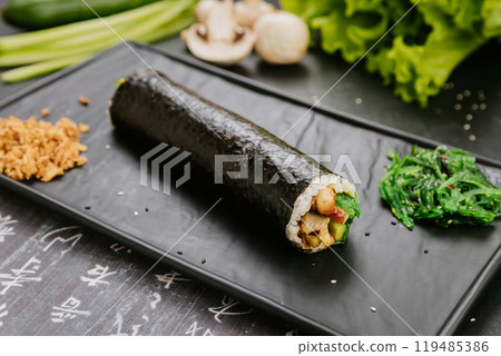 Gimbap roll with fresh vegetables, mushrooms and chicken, served with seaweed salad and fried onions 119485386