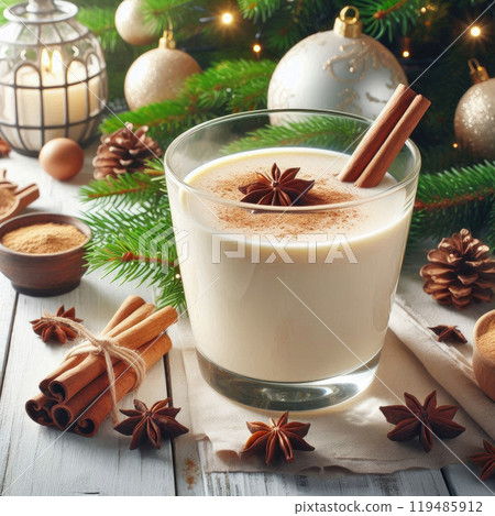 Christmas drink with cinnamon sticks and anise stars, glass of sweet classic eggnog cocktail decorated background with fir tree and baubles 119485912