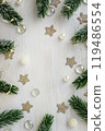 Vertical festive background with Christmas branches and lights with space for text. White wooden table 119486554