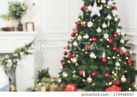 Blurred Background Christmas tree decorated holiday winter xmas celebration. Present gift decorate under bauble ornament silver red ball on christmas tree in cozy living room. Blurry background 119486693