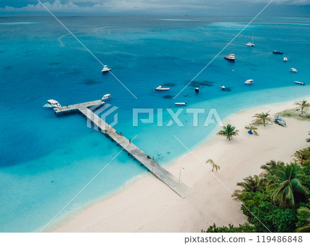 Above view of beach with pier and boats on island. Travel vacation destination, Fulidhoo island. Above view of beach with pier and boats on island. Travel vacation destination, Fulidhoo island. 119486848