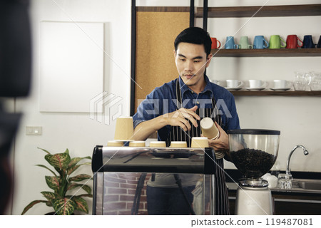 Coffee barista man make espresso shot from coffee maker hot cup. Cappuccino with milk in italian coffee shop cafe. Close up hands of barista use machine make brown latte art for customer cafeteria Coffee barista man make espresso shot from coffee maker hot cup. Cappuccino with milk in italian coffee shop cafe. Close up hands of barista use machine make brown latte art for customer cafeteria 119487081