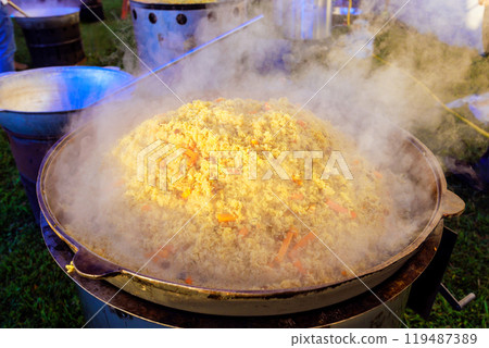 In process of cooking Turkish pilaf, large cast iron cauldron is used In process of cooking Turkish pilaf, large cast iron cauldron is used 119487389