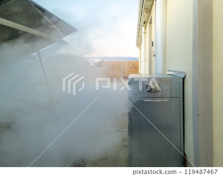 Steaming central heating boiler outside house in Ireland 119487467