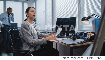 Adult, beautiful female analyst checking data in paper documents Adult, beautiful female analyst checking data in paper documents 119488922