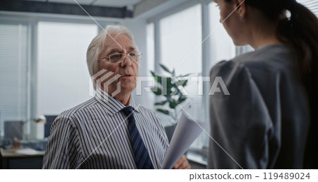 Senior boss of the company with papers talks to female financial specialist Senior boss of the company with papers talks to female financial specialist 119489024