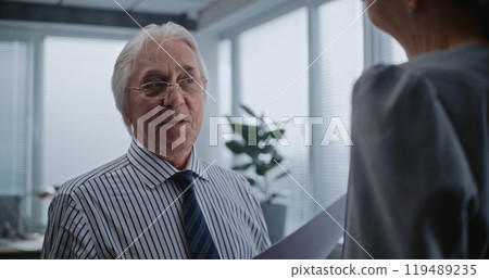 Senior boss of the company with papers talks to female financial specialist 119489235