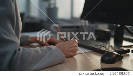In modern office: Close up of female financial specialist taking notes 119489265