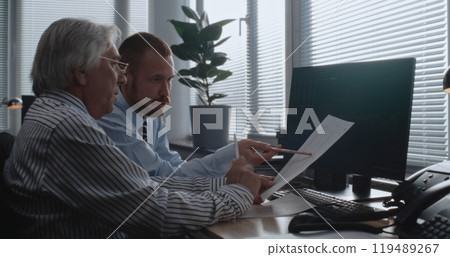 Corporate business partners monitor equity market and shares on computer, discuss strategy 119489267