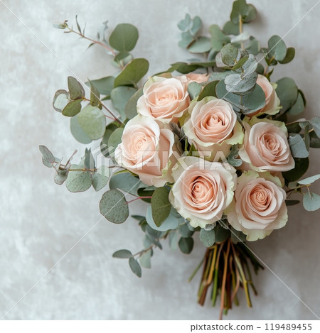 Elegant bouquet of soft pink and cream roses with eucalyptus leaves arranged for special occasions 119489455