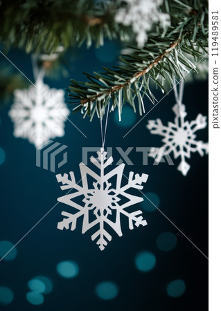Decorated Christmas tree with white snowflake ornaments against a dark blue backdrop at winter 119489581