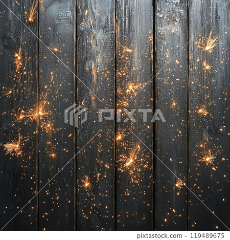 Sparks flying across a wooden surface during a celebration at night with a dark background 119489675