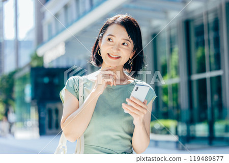 Woman operating a smartphone outdoors 119489877