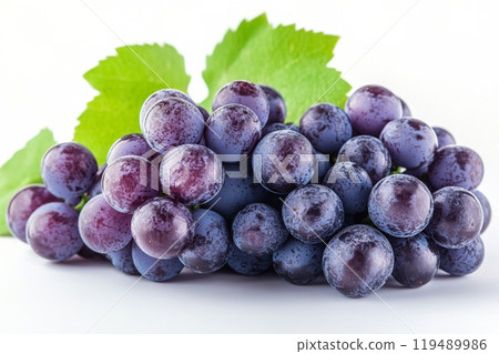 Freshly harvested purple grapes with water droplets and green leaves on a white background 119489986