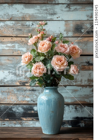 Beautiful pastel roses in a ceramic vase against a rustic wooden backdrop 119490345