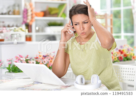 A young emotional girl uses a laptop at home 119491583