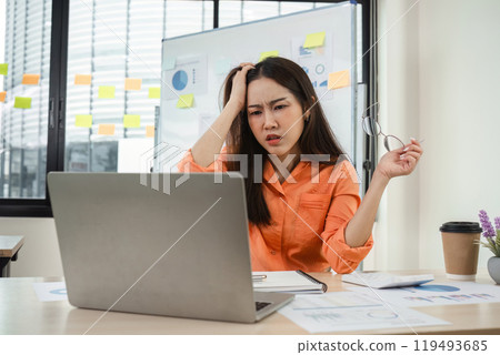 Young Businesswoman Feeling Stressed at Work, Overwhelmed with Tasks, Experiencing Work Pressure in Modern Office Environment Young Businesswoman Feeling Stressed at Work, Overwhelmed with Tasks, Experiencing Work Pressure in Modern Office Environment 119493685