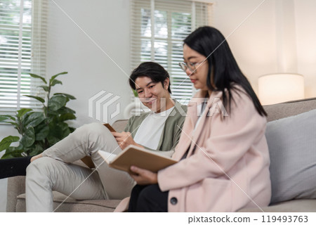 Mother and Son Enjoy Quality Time Together Relaxing in a Modern Living Room with Natural Light 119493763