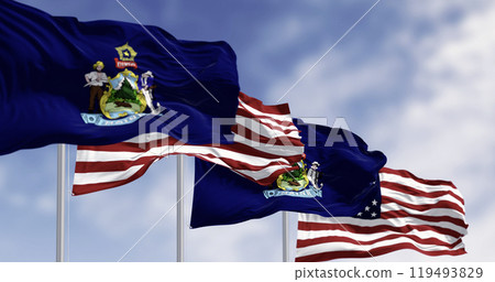 Maine state flags and the American flag waving in the wind on a clear day 119493829