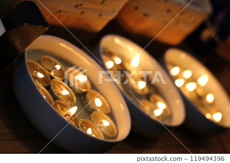 Round Trays With Burning Tablet Candles Angle View   119494396