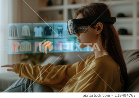 woman wearing VR goggles, employing spatial technology, browse through an digital clothing catalog 119494762