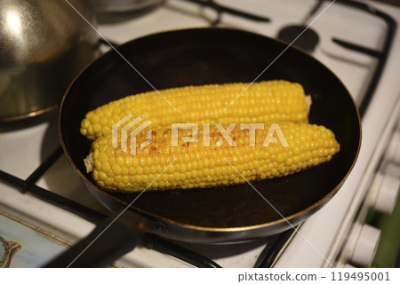 Frying corn in a frying pan. A delicacy made of corn. Frying corn in a frying pan. A delicacy made of corn. 119495001