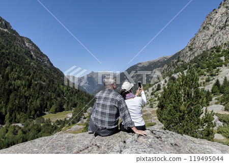 Tourist couple looking at the pike of mountain Pyrenees in Catalonia of Spain Tourist couple looking at the pike of mountain Pyrenees in Catalonia of Spain 119495044
