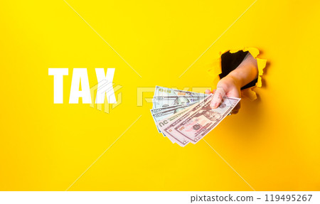 Hand holding cash with tax text on yellow background Hand holding cash with tax text on yellow background 119495267