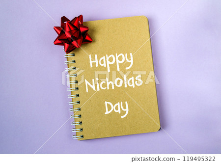 A notebook with a red bow on it with the words Happy Nicholas Day written on it 119495322