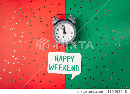 A clock is on a green background with a white sign that says Happy Weekend A clock is on a green background with a white sign that says Happy Weekend 119495348