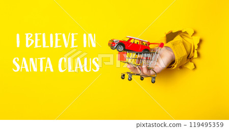 Hand holding a toy car in front of a yellow background Hand holding a toy car in front of a yellow background 119495359