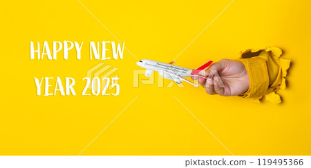 Hand holding a toy airplane in front of a yellow background Hand holding a toy airplane in front of a yellow background 119495366
