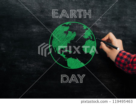 A person is drawing a green Earth on a blackboard with a marker A person is drawing a green Earth on a blackboard with a marker 119495463