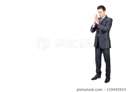 Serene man in suit praying with closed eyes 119495654
