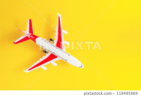 Small white and red airplane is flying over a yellow background Small white and red airplane is flying over a yellow background 119495869
