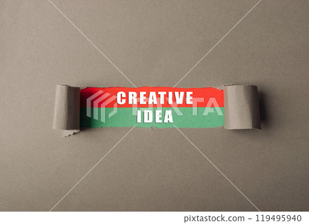 Piece of paper with the word creative idea written on it 119495940