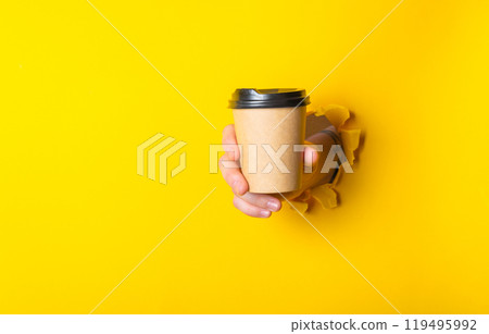 Person is holding a coffee cup with a lid in their hand 119495992