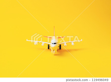 Yellow toy airplane is sitting on a yellow background 119496049