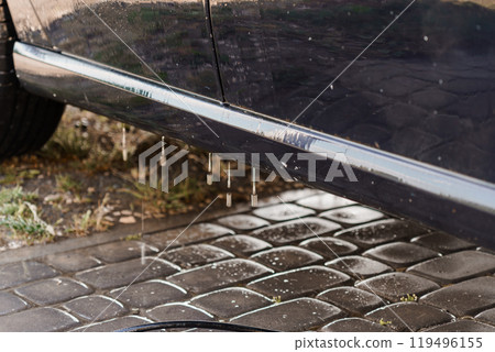 Clean Car Exterior with Water Dripping from Side Panel on Cobblestone Driveway Clean Car Exterior with Water Dripping from Side Panel on Cobblestone Driveway 119496155
