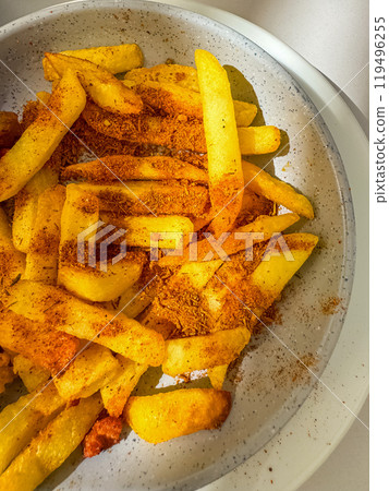 Golden crispy fries sprinkled with spices served in a speckled ceramic bowl. High quality photo Golden crispy fries sprinkled with spices served in a speckled ceramic bowl. High quality photo 119496255