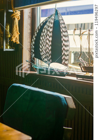 Decorative miniature sailboat on a windowsill in a nautical-themed room. High quality photo Decorative miniature sailboat on a windowsill in a nautical-themed room. High quality photo 119496297