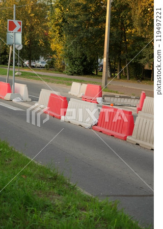 Red, white plastic safety barriers along roads. Ensuring road safety with visible barriers 119497221