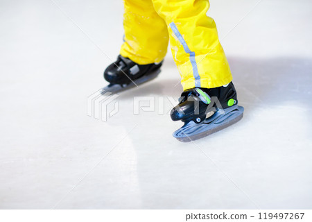 Child skating on indoor ice rink. Kids skate. Child skating on indoor ice rink. Kids skate. 119497267