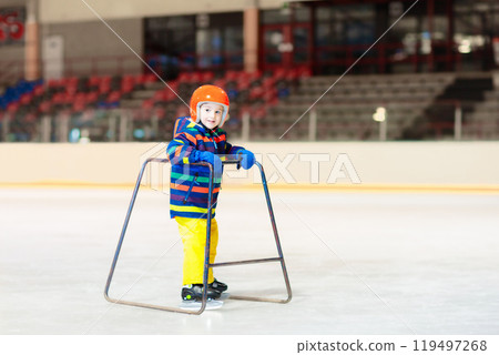 Child skating on indoor ice rink. Kids skate. Child skating on indoor ice rink. Kids skate. 119497268