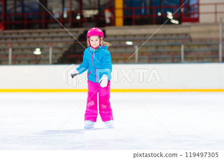 Child skating on indoor ice rink. Kids skate. 119497305