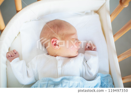 Newborn baby boy in hospital cot 119497350