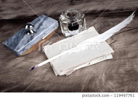 Vintage retro fountain pen and inkwell with old letters on a wooden table 119497761