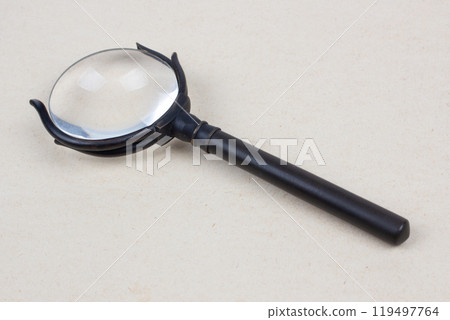Antique magnifying glass on paper 119497764