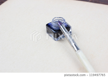 Vintage pen and inkwell on paper background Vintage pen and inkwell on paper background 119497765