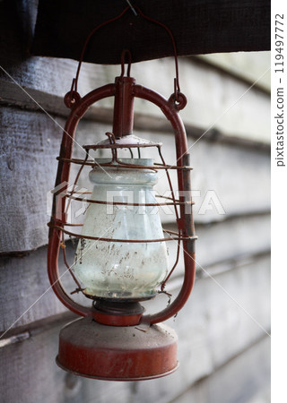 Antique rusty kerosene lantern on wooden wall. Antique rusty kerosene lantern on wooden wall. 119497772